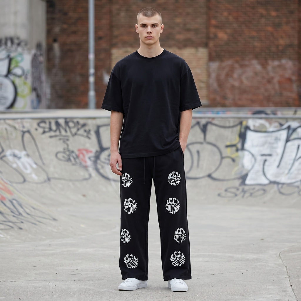 Icy Culture black fleece sweatpants with drawstring and all-over white logo print. Straight-leg, casual style.