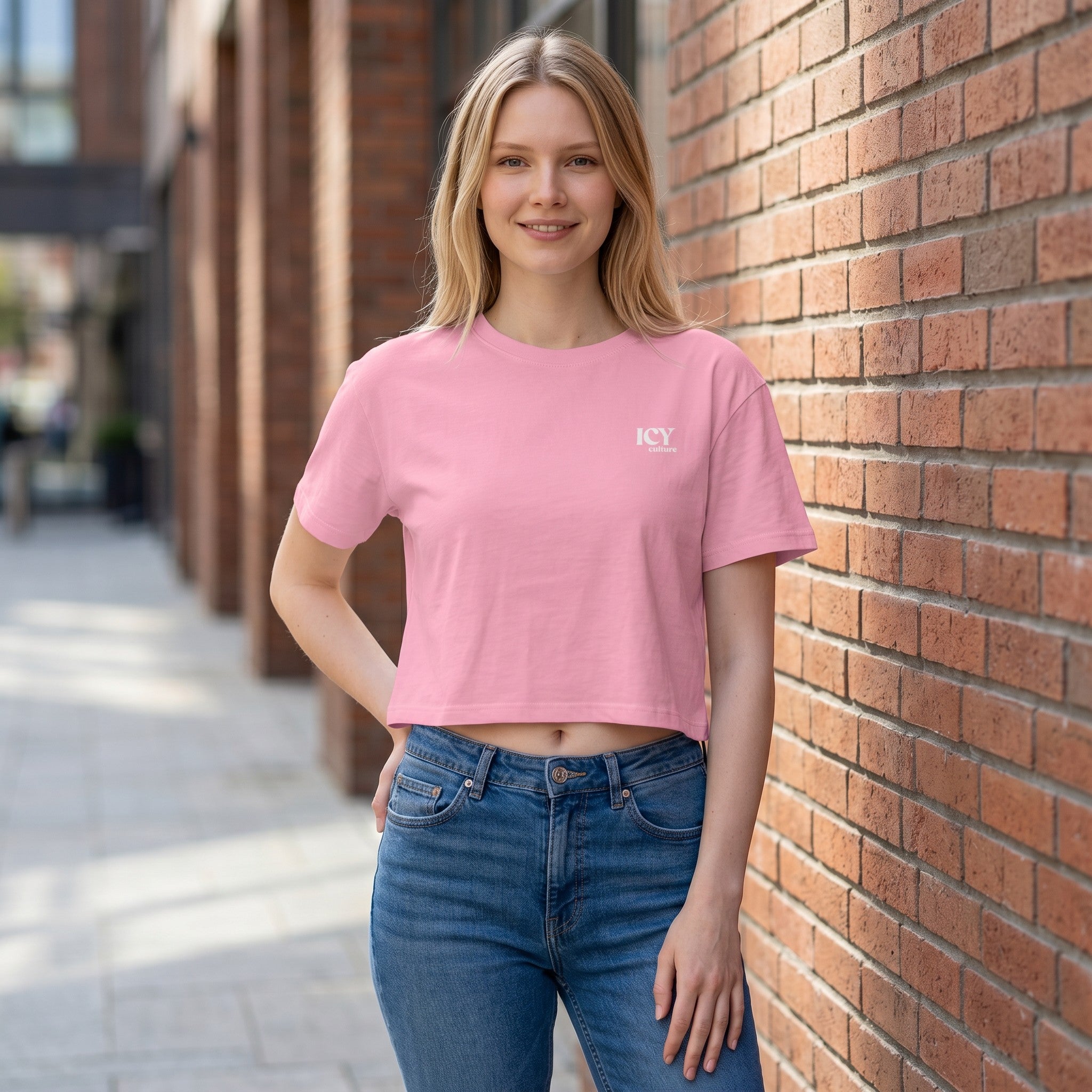 Icy Culture crop tee em rosa, 100% algodão penteado, com logótipo branco discreto no peito e ombros descaídos.